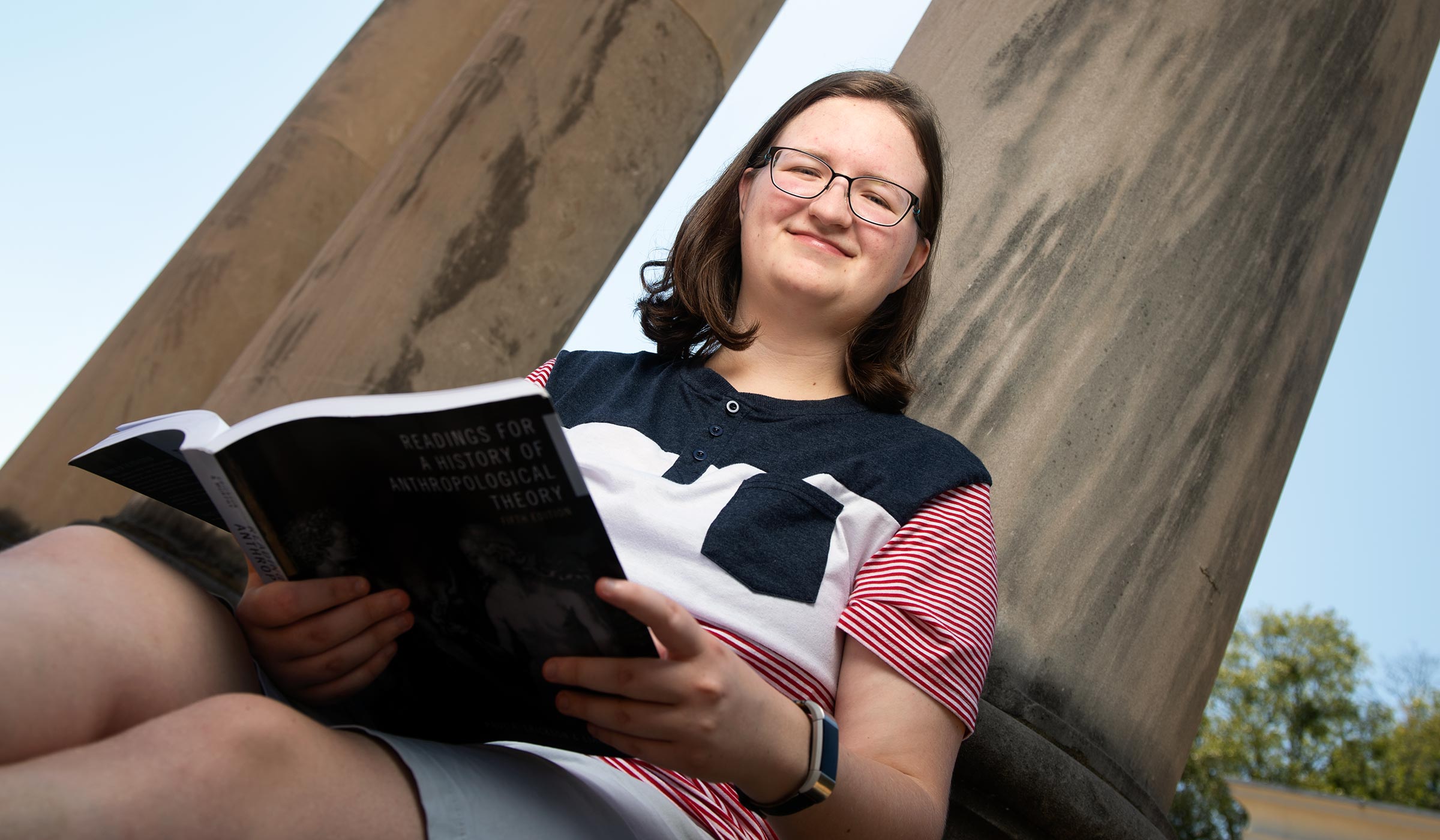 Laura Ingouf, pictured reading in front of a column on campus.