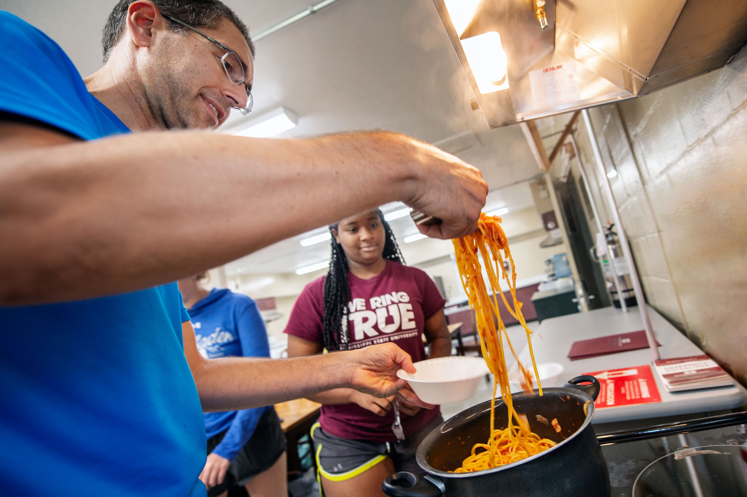 Classics Professor Salvador Bartera serves up freshly cooked pasta to First Year Experience students after an Italian cooking lesson.