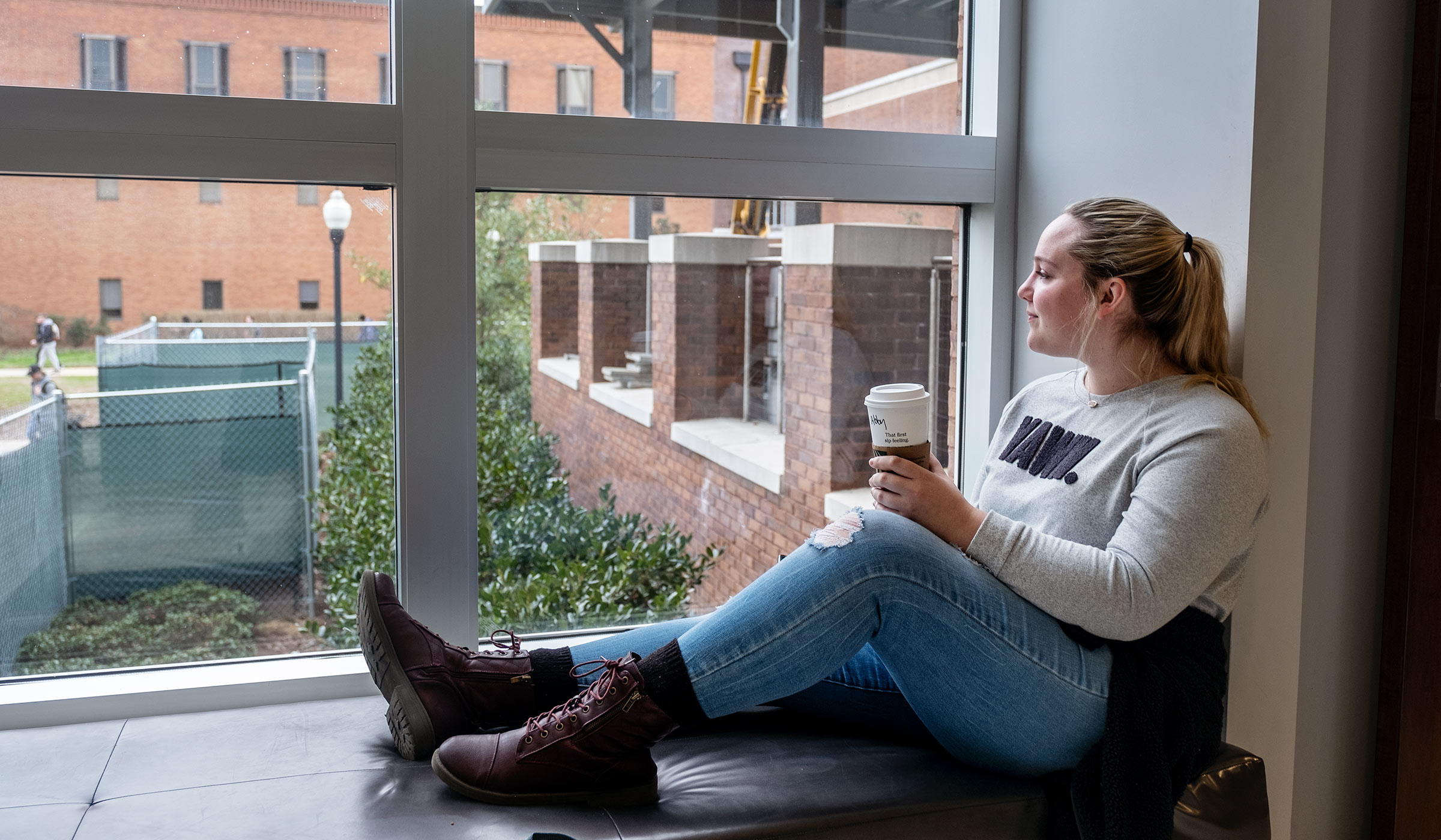 Student Abi Martin takes a coffee break on a Union Bench.