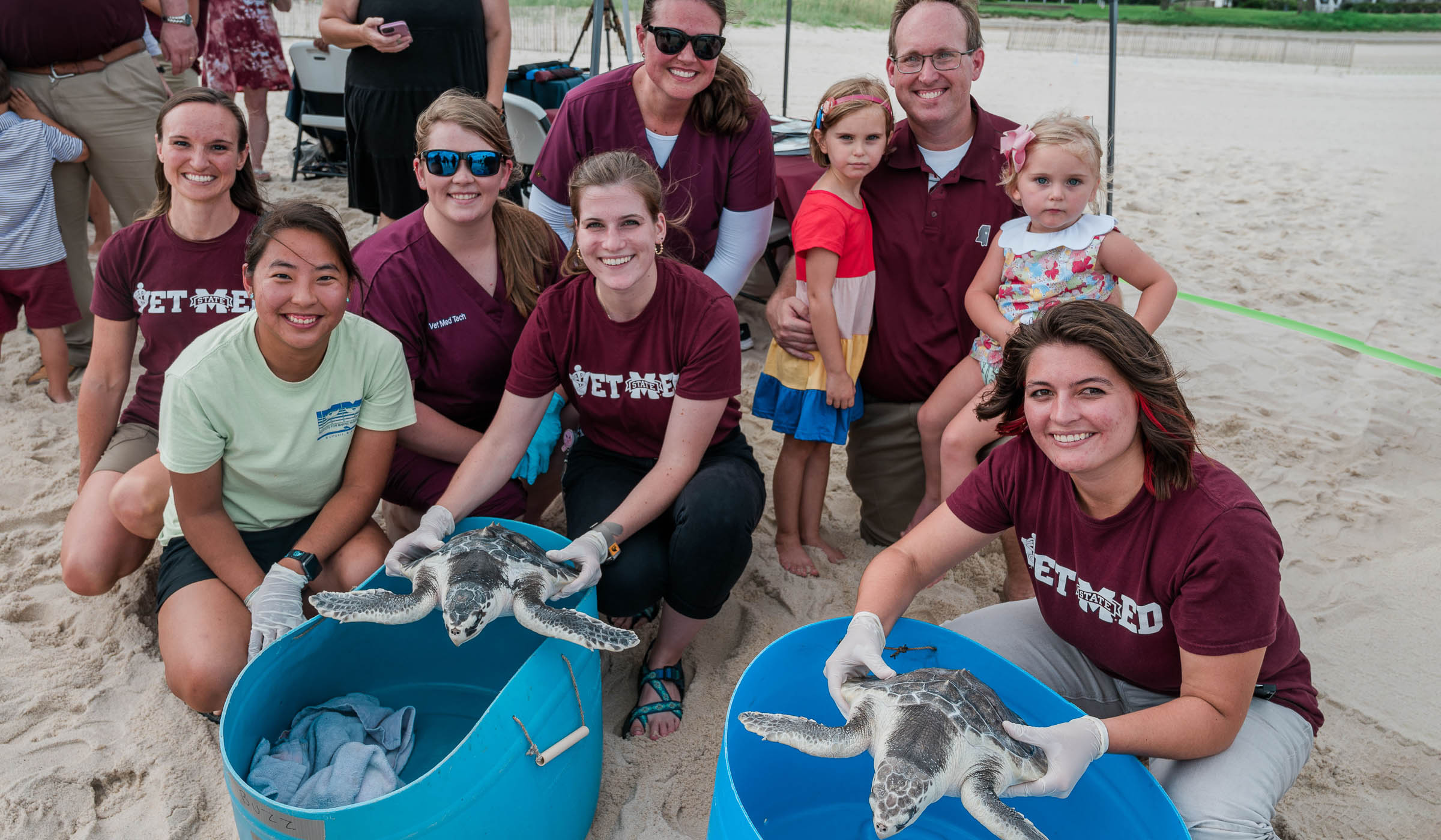 Group posing around sea turtles