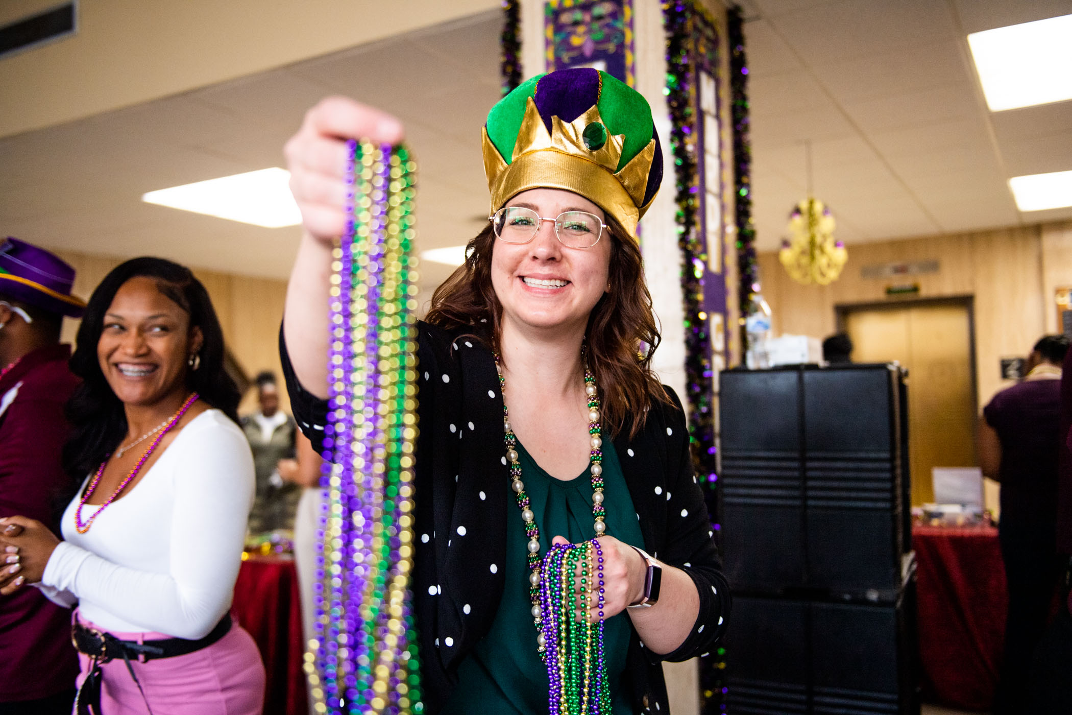 Lilli Harris, Grad Student Development Coordinator at MSU&#039;s Graduate School, holds out colorful beads- a long time Mardi Gras tradition, for a photo.
