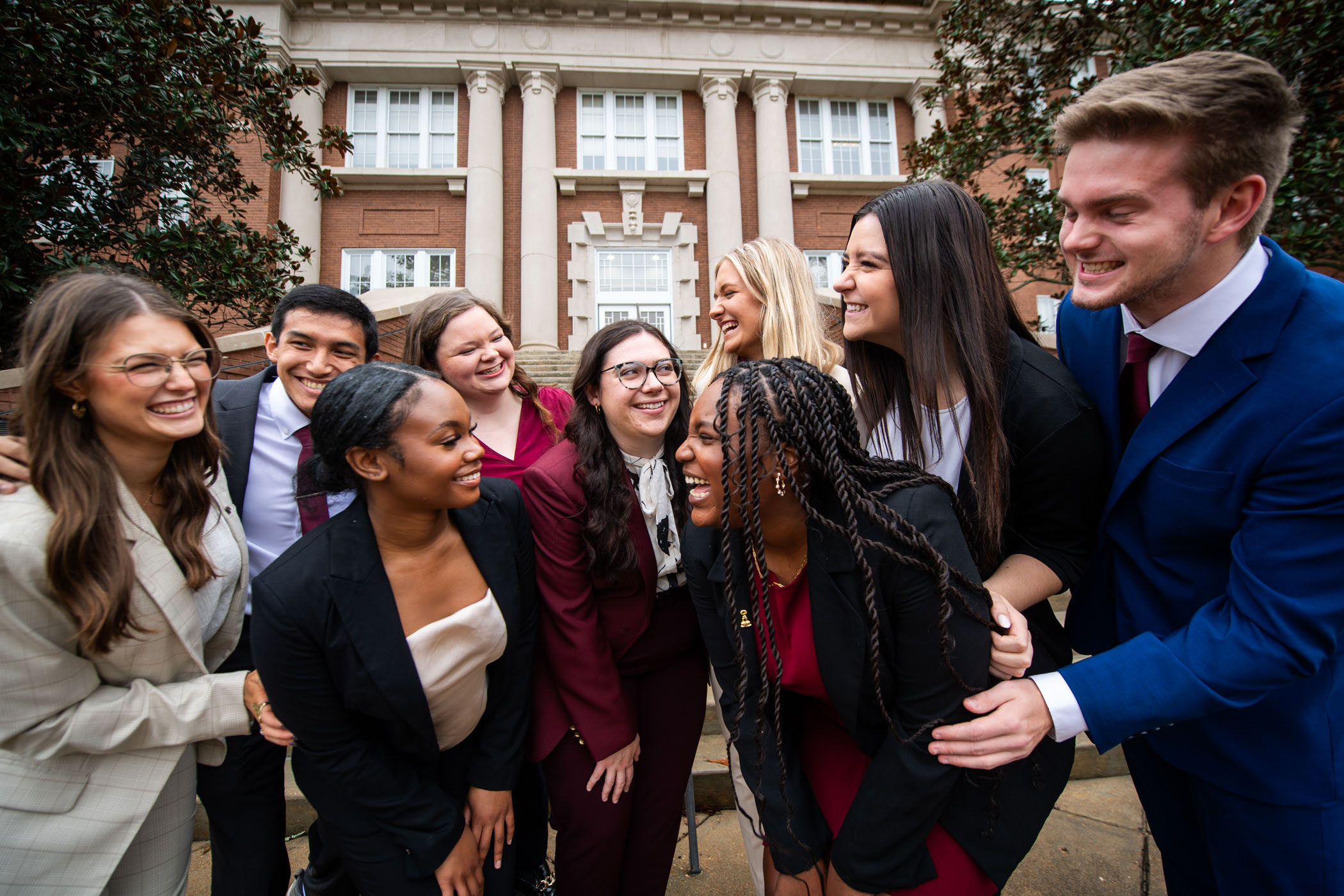 MSU Student Association Executive Council members lean in for hugs and laughs in front of the Swalm Chemical Engineering building