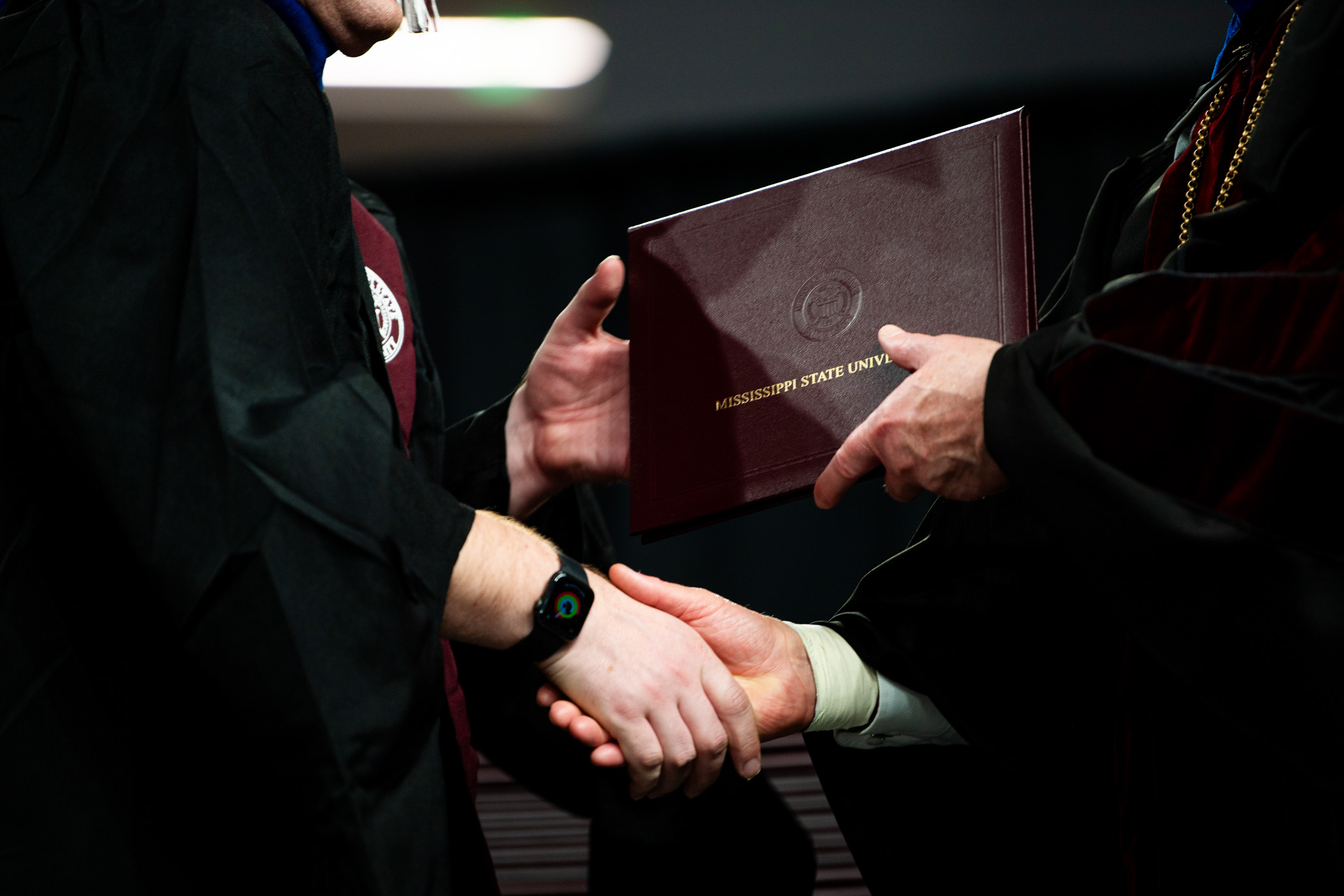 MSU President hands off a diploma to a graduate, signifying the end of an academic journey and start to a new chapter. v