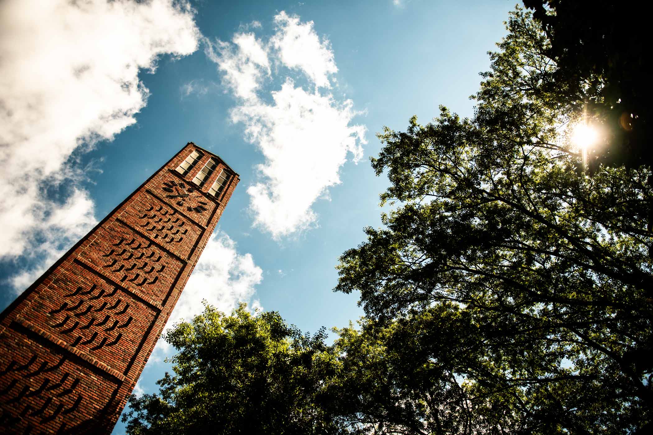 The MSU Chapel of Memories&#039; bell tower bathes in golden sunlight high in the sky. Opened in 1967, the chapel features bricks that previously served as the exterior of Old Main, the legendary student residence hall thought to be the largest dormitory in the nation before it was destroyed in a 1959 fire.