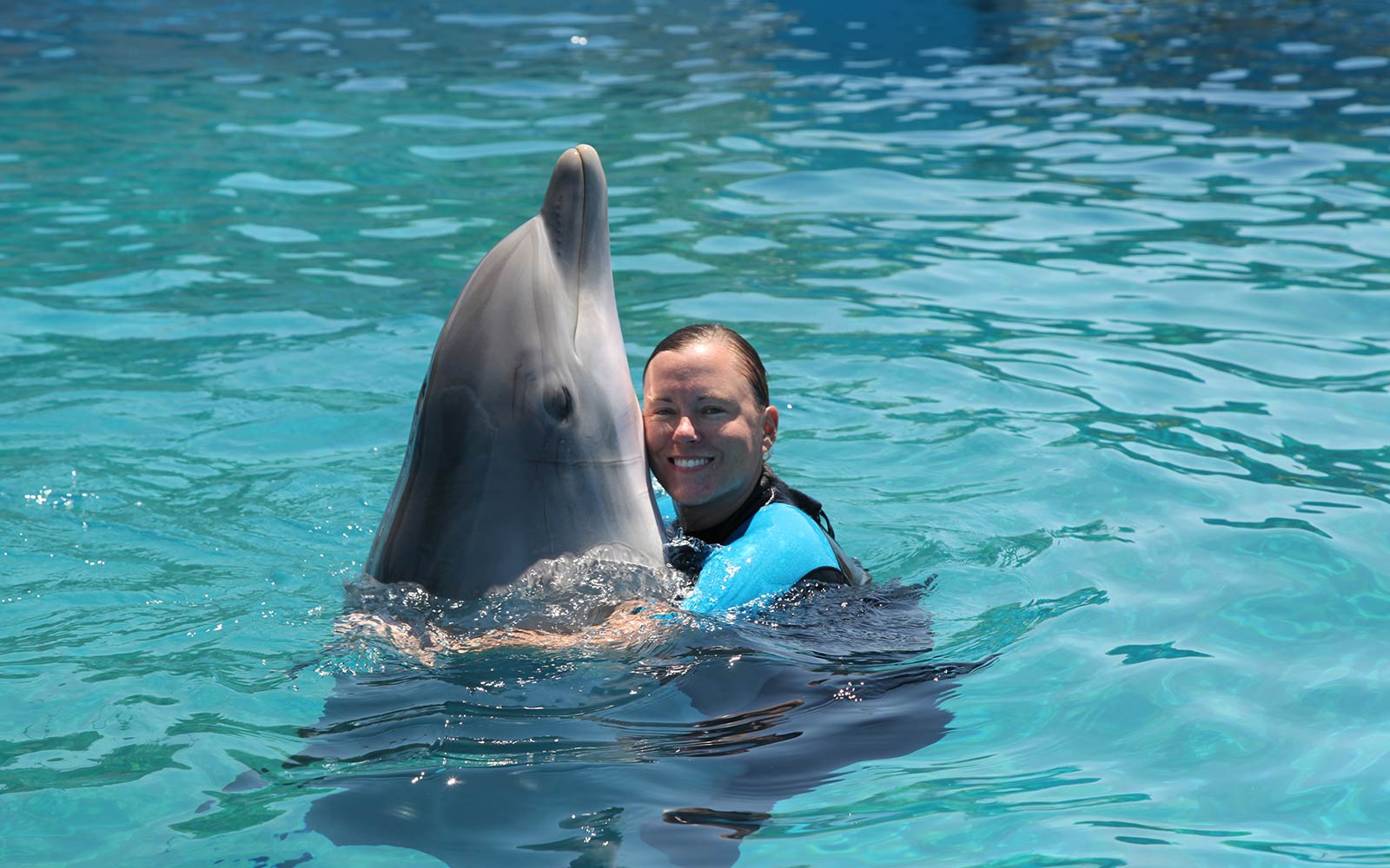 Holley Muraco hugs a dolphin