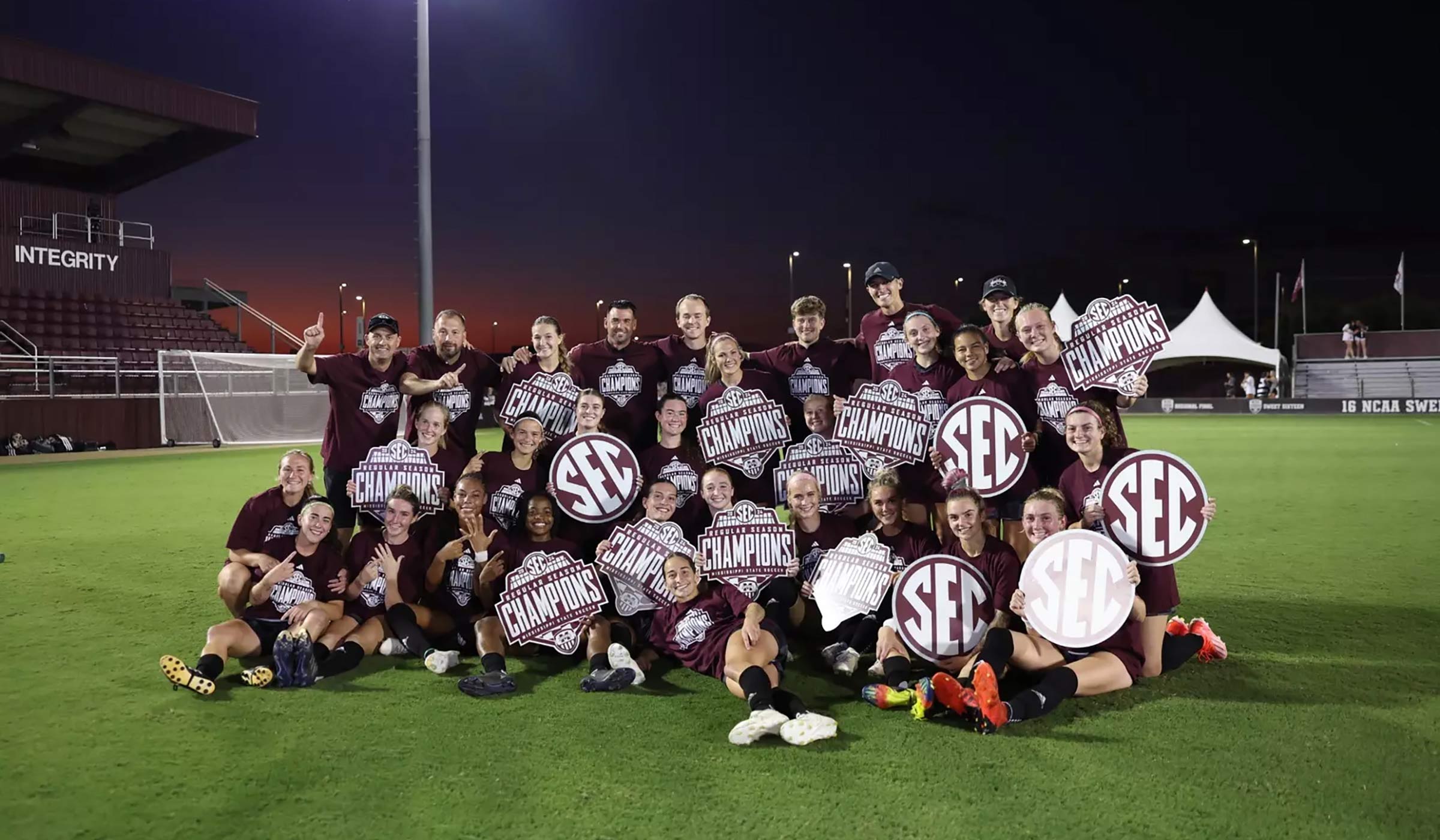 Female soccer team with SEC Champs signage