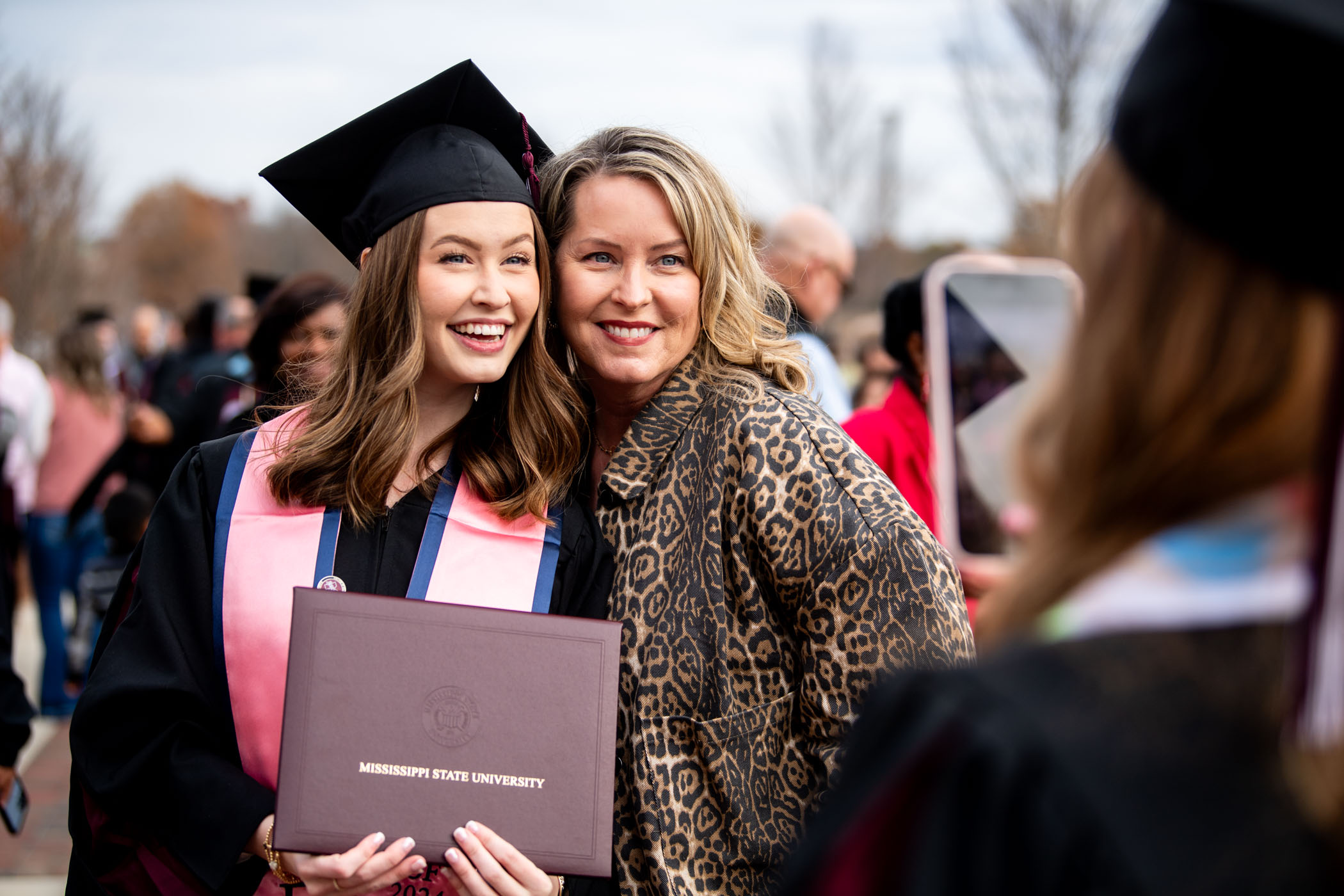 Layne Bjornseth, a recent graduate of MSU&#039;s Elementary Education program, beams with pride as she holds up her diploma for a celebratory cellphone snapshot alongside her mother, Shannon Bjornseth, following the fall commencement ceremony on Friday morning, [Dec 13.]  Layne is among the many new members who crossed the stage to join the MSU Alumni family.