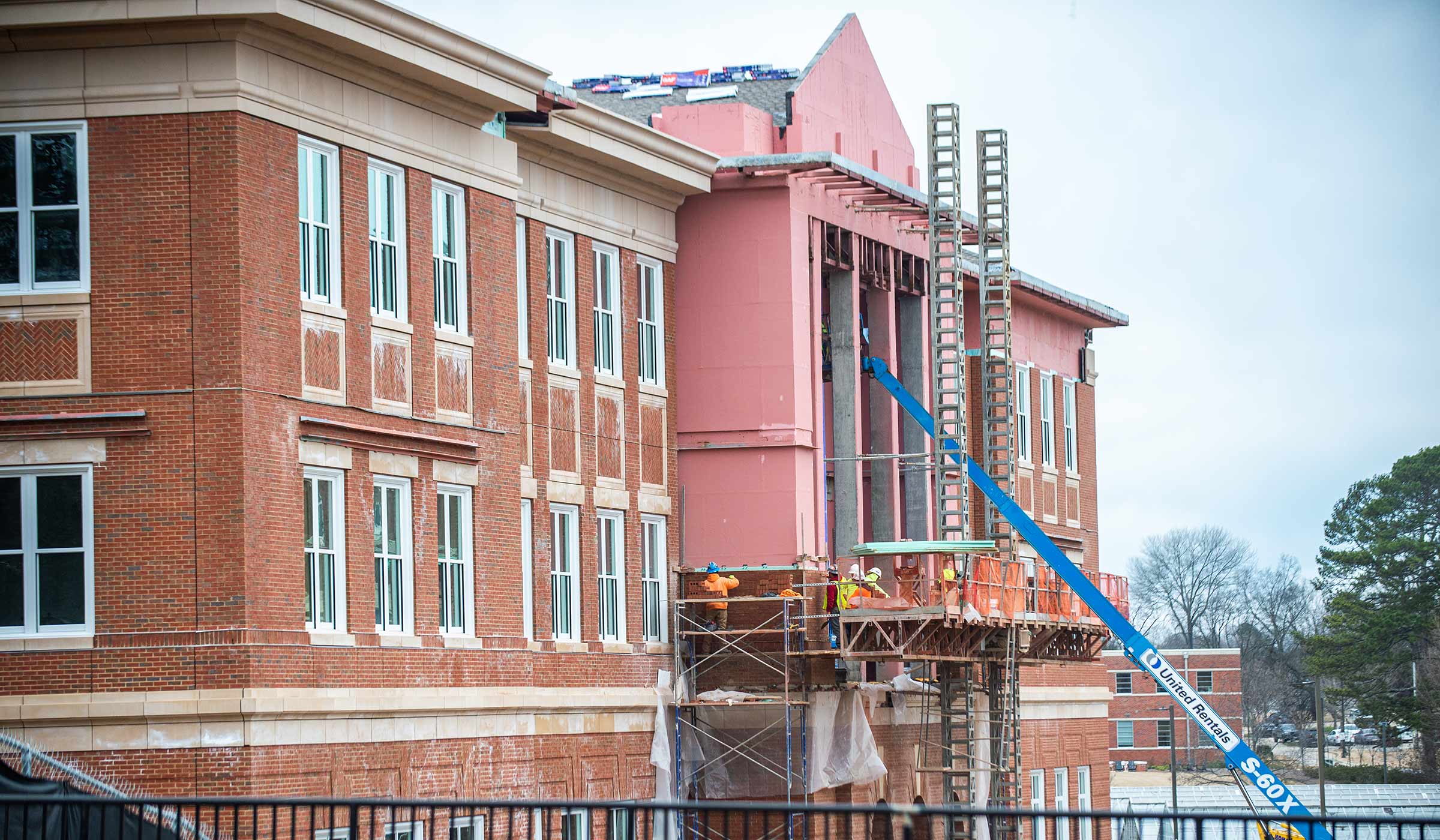 Construction in progress on exterior of brick building