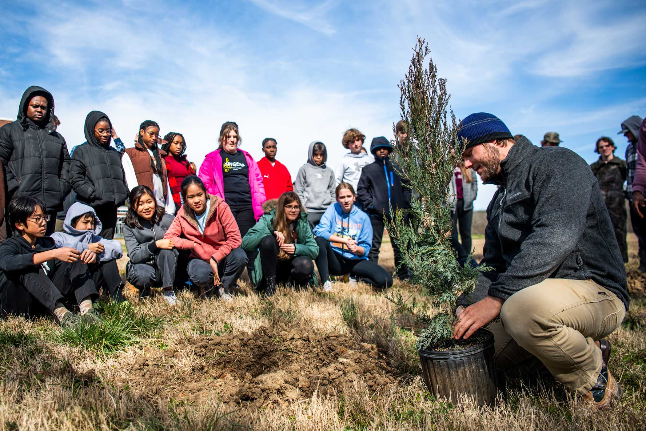 Drew Williams, a candidate in MSU&#039;s Forest Resources&#039; Ph.D. program, demonstrates how to plant seedlings to Partnership Middle School students at a join planting exercise in celebration of Arbor Day [Feb 21.] 