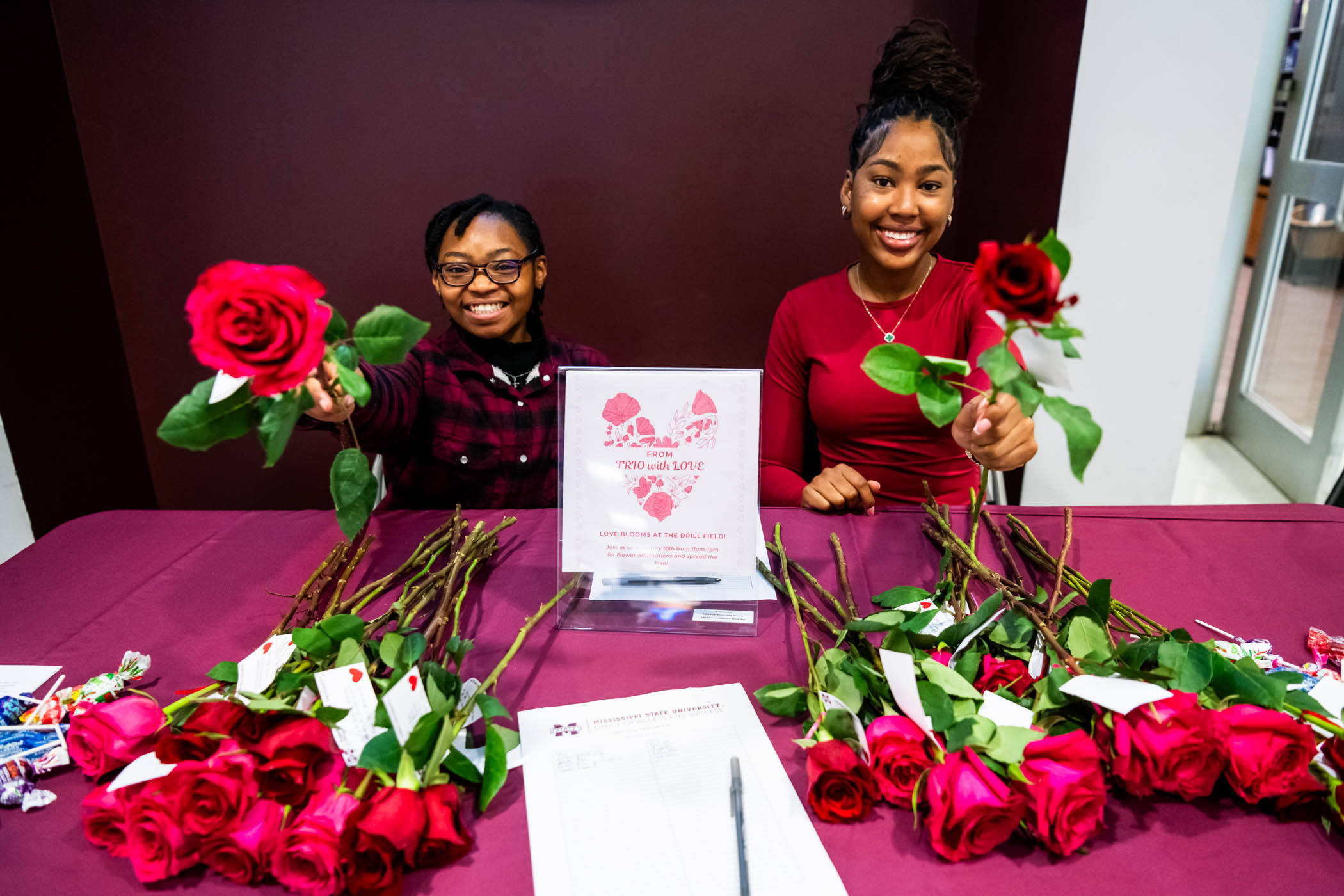 TRiO students Aisha Williams, a junior management major (left) and senior Bio Sciences major, Kasia Williams (right,) spread kindness by handing out roses, each accompanied by a note of positive affirmations to kick off the week of Valentine&#039;s Day. 