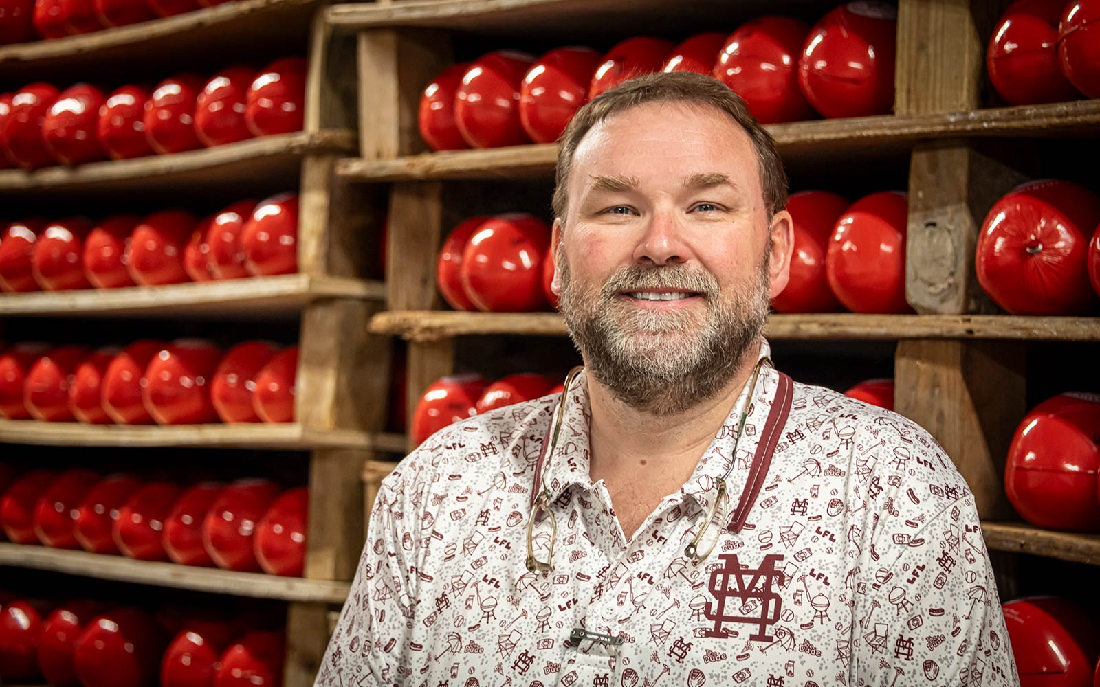 photo of TJ Evans in front of a wall of cheese