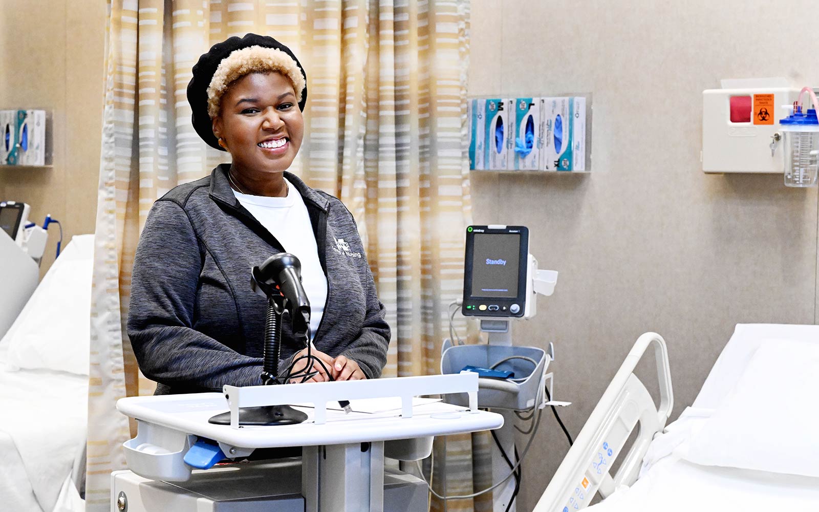 Photo of Francesca Williams in a hospital room next to machine