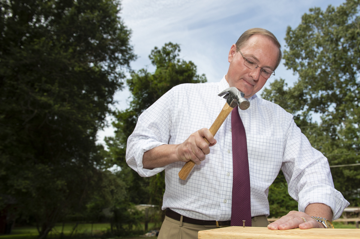 MSU President Mark E. Keenum drives the first nail during the Habitat for Humanity groundbreaking ceremony.