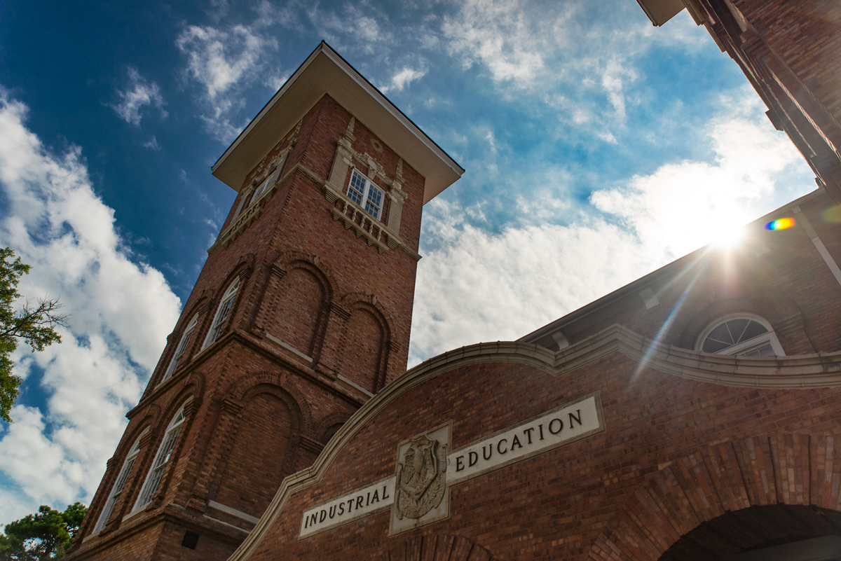 The Industrial Education Building with partly cloudy blue skies behind the 2 large towers