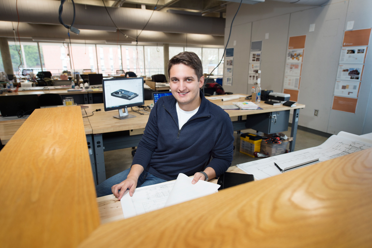 Collin Manuel, pictured at a large desk working on a project.