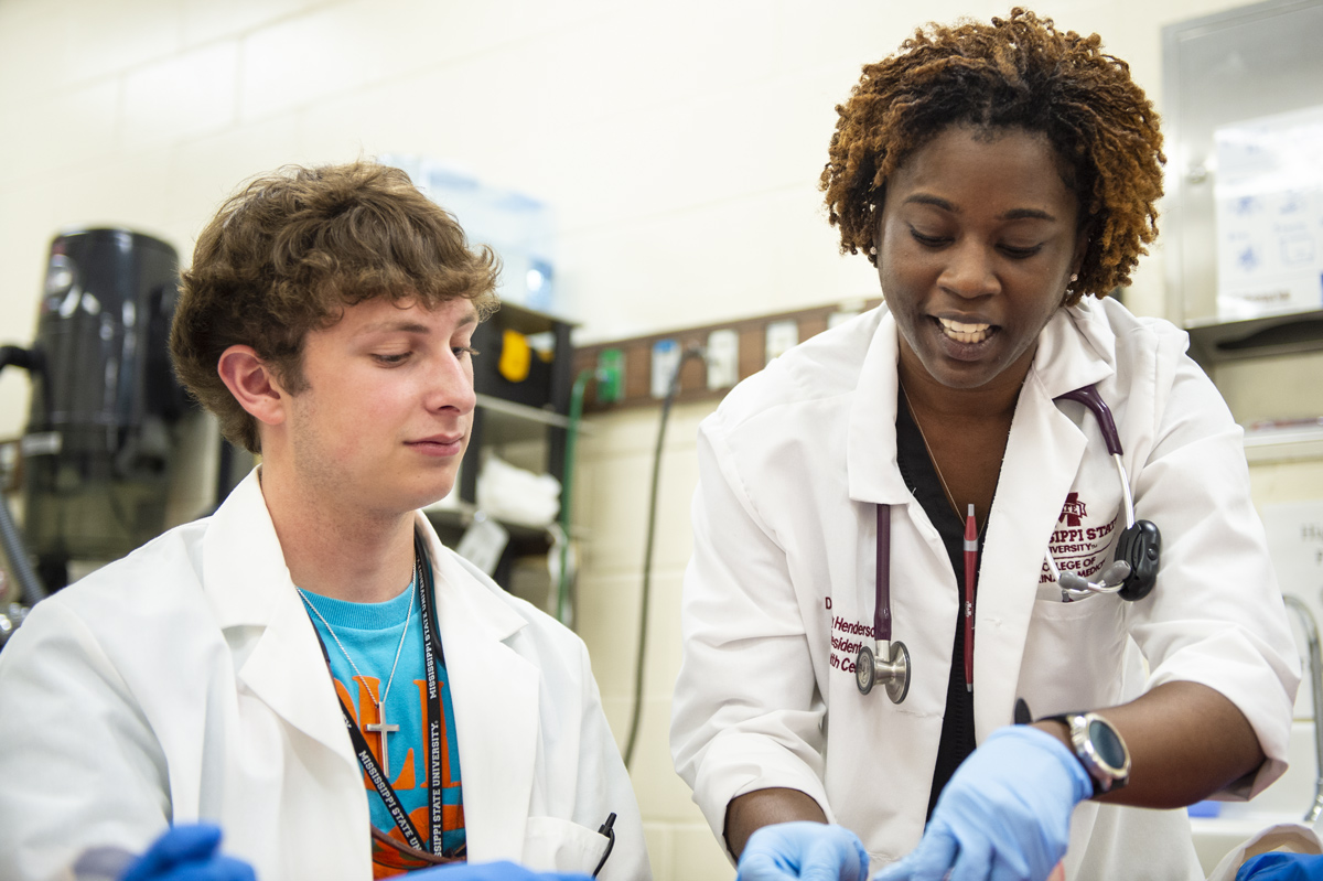 Curt Todd receives instructions from Dr. Brittany Moore-Henderson on how to properly suture wounds.