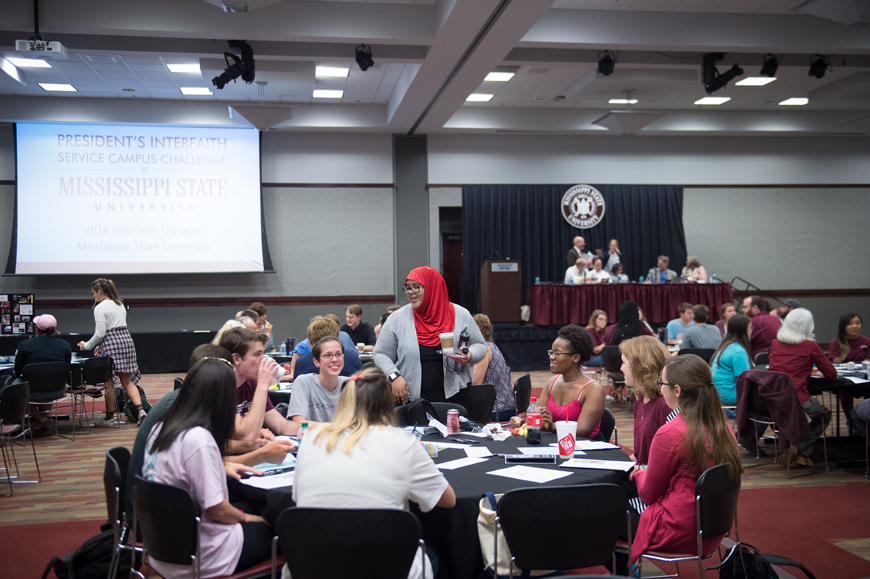 Roundtables of diverse students and faculty talk in Colvard Union ballroom during 2016 MSU Interfaith Dialogue.