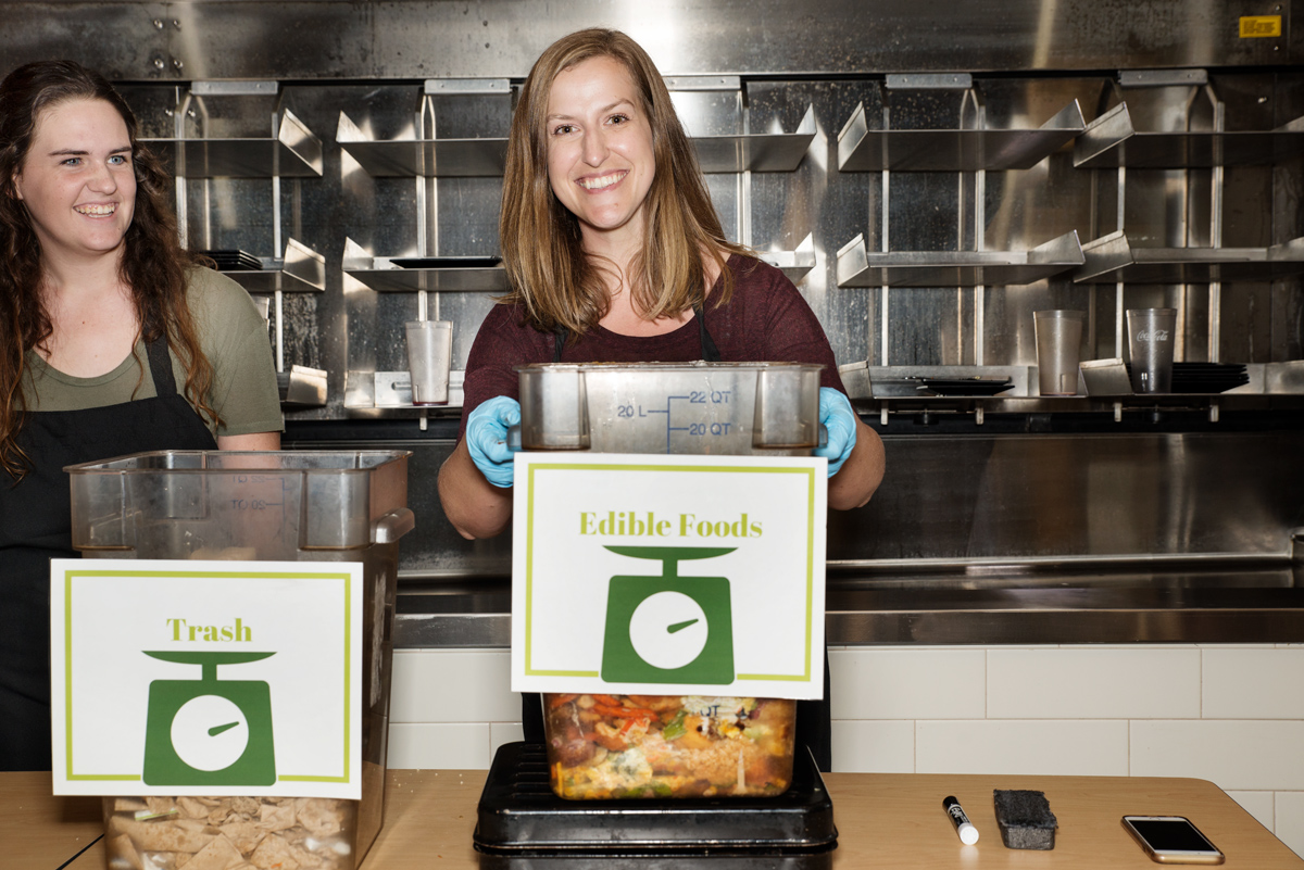 Student Taylor Saucier and Sustainability Coordinator Christine Lashley weigh food and waste from lunch diners at Fresh Foods.