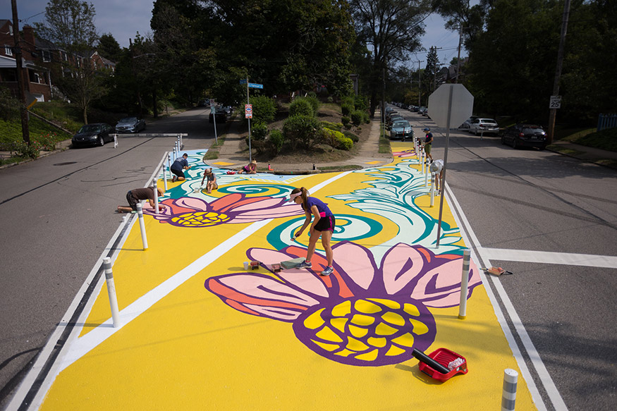 People painting a mural on a street in Pittsburg, Pennsylvania