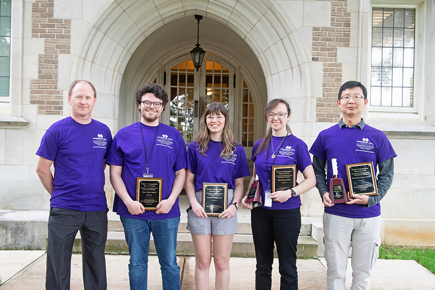 MSU Biological Sciences Department Head Angus Dawe (left to right) congratulates Biological Sciences Undergraduate Research Program symposium third-place winner John C. Vines of Philadelphia, second-place winner Amber Travis of Ocean Springs, first-place winner Sara Tyrrell of North Augusta, South Carolina and First Place Mentor Award Winner Ying Wang. (Photo by Beth Wynn)