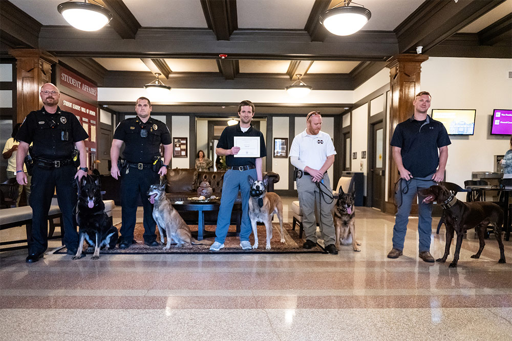 Along with retiring K-9 Bach, center, other MSU and local police dogs are pictured with their handlers.