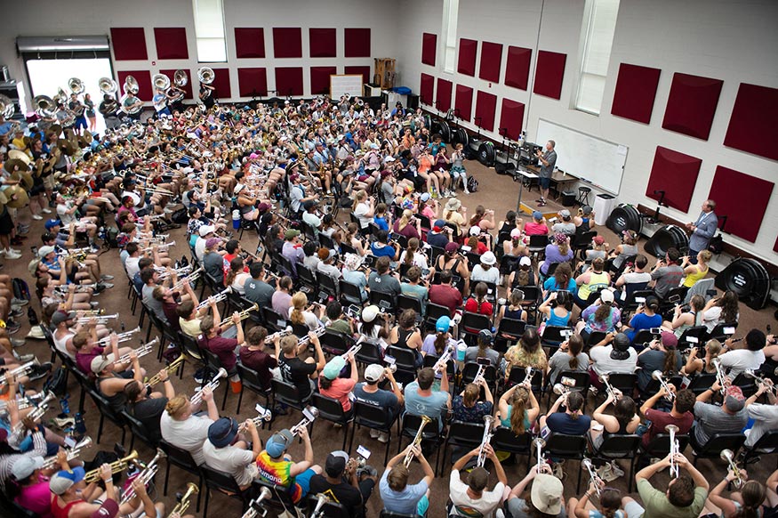 Members of the Famous Maroon Band rehearse in the band hall as MSU President Mark Keenum listens