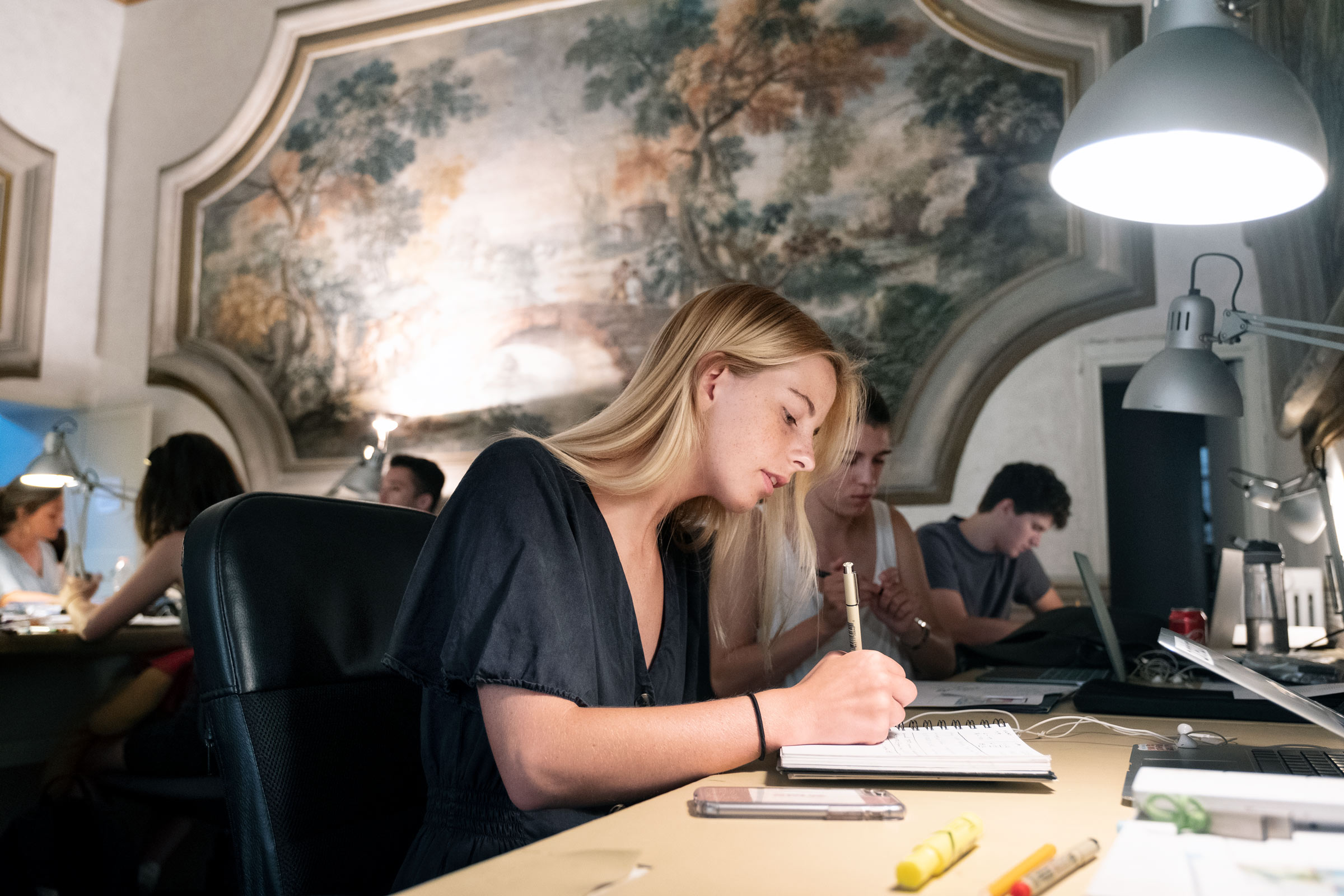 T.J. Barnett writes in a notebook during her study abroad trip in Italy.