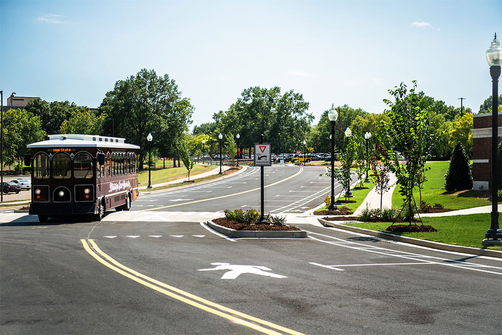 A classic MSU trolley is the first vehicle to drive the newly opened College View Drive gateway onto campus