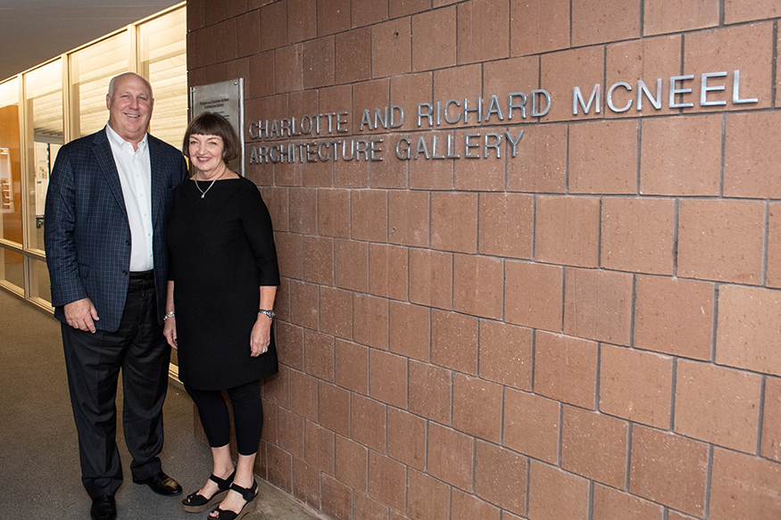 MSU alumni Richard and Charlotte McNeel stand near the sign outside of the Giles Hall architecture gallery that now bears their name.