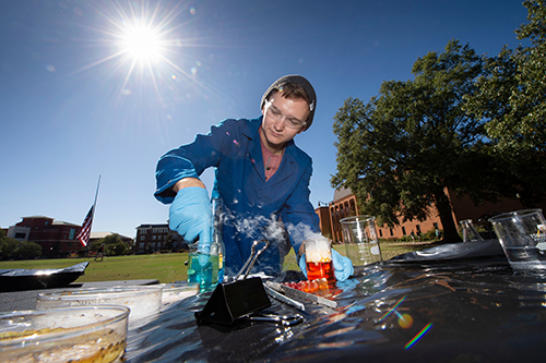 A chemistry student demonstrates chemical reactions outside on MSU's Drill Field