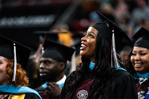 An MSU graduate smiles during commencement.