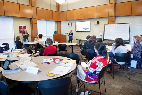 Cade Smith (standing left), assistant dean and director of student leadership and community engagement, interacts with faculty and non-formal teaching staff participants in the inaugural Community-Engaged Learning Fellows program, as Meggan Franks, assistant director, leads a session from the podium on preparing students to work with the community. The 15 MSU employees worked to redesign or propose a class incorporating community-engagement principles into the learning process. (Photo by Megan Bean) 