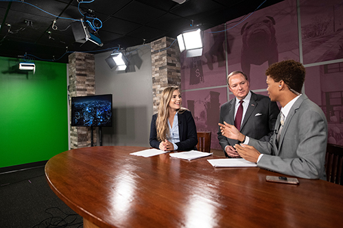 MSU President Mark E. Keenum visits with students using a television broadcast studio, part of MSU’s new MaxxSouth Digital Media Center in Mitchell Memorial Library. 