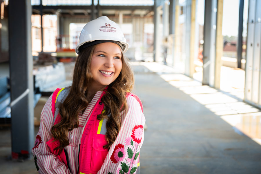 a young woman wearing a construction hat and vest