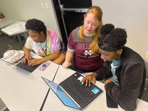 Students work at computers during a summer cybersecurity camp.