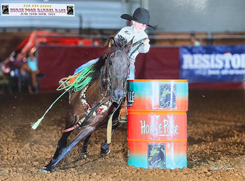 A boy and horse round a barrel at the Mississippi Horse Park's 2019 Horse Poor Barrel Race.