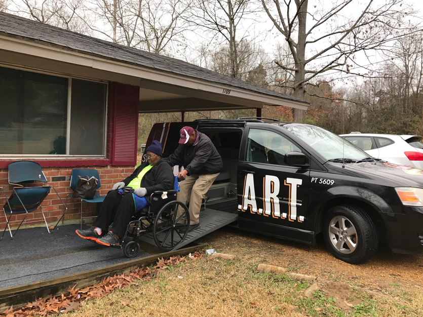 Paratransit driver James Johnson helps Earner Williams into the van that will take her to her dialysis appointments in Starkville. (Photo by Hannah Howell) 