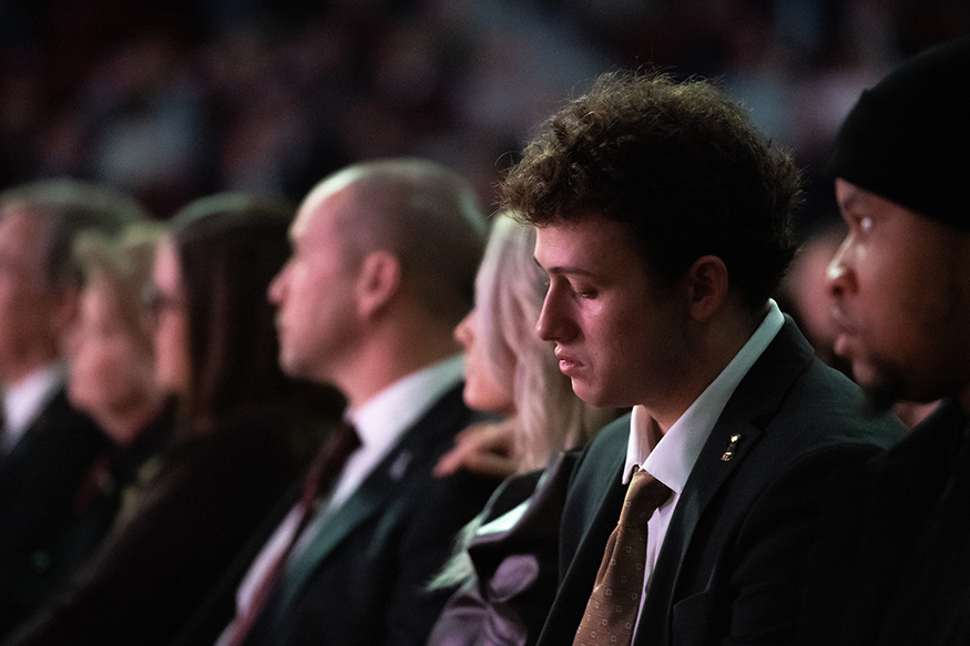 MSU football players Will Rogers and Nathaniel Watson listen during the program at Humphrey Coliseum.