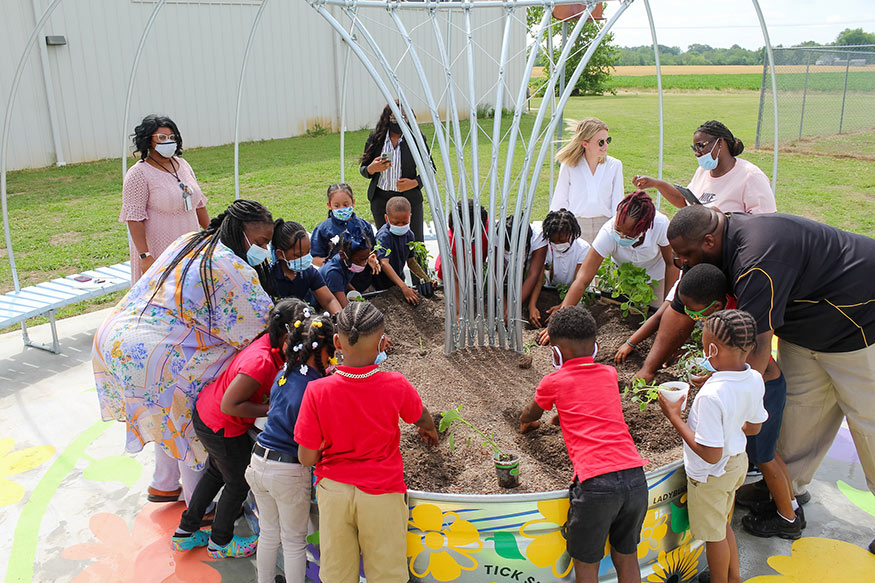 Young students and teachers plant in part of the new learning garden at Leflore County Elementary School