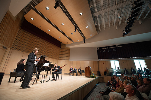 Faculty members perform on stage during a ribbon cutting ceremony