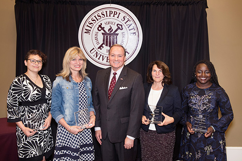 Pictured with MSU President Mark E. Keenum, center, Mississippi State University President’s Commission on the Status of Women’s 2018 Outstanding Women award recipients include, left to right, Sarah E. “Izzy” Pellegrine, Leslie Fye, Keenum, Leslie Hossfeld and Terranecia L. “Bria” Henderson. Not pictured is Feifei Zeng. (Photo by Beth Wynn)