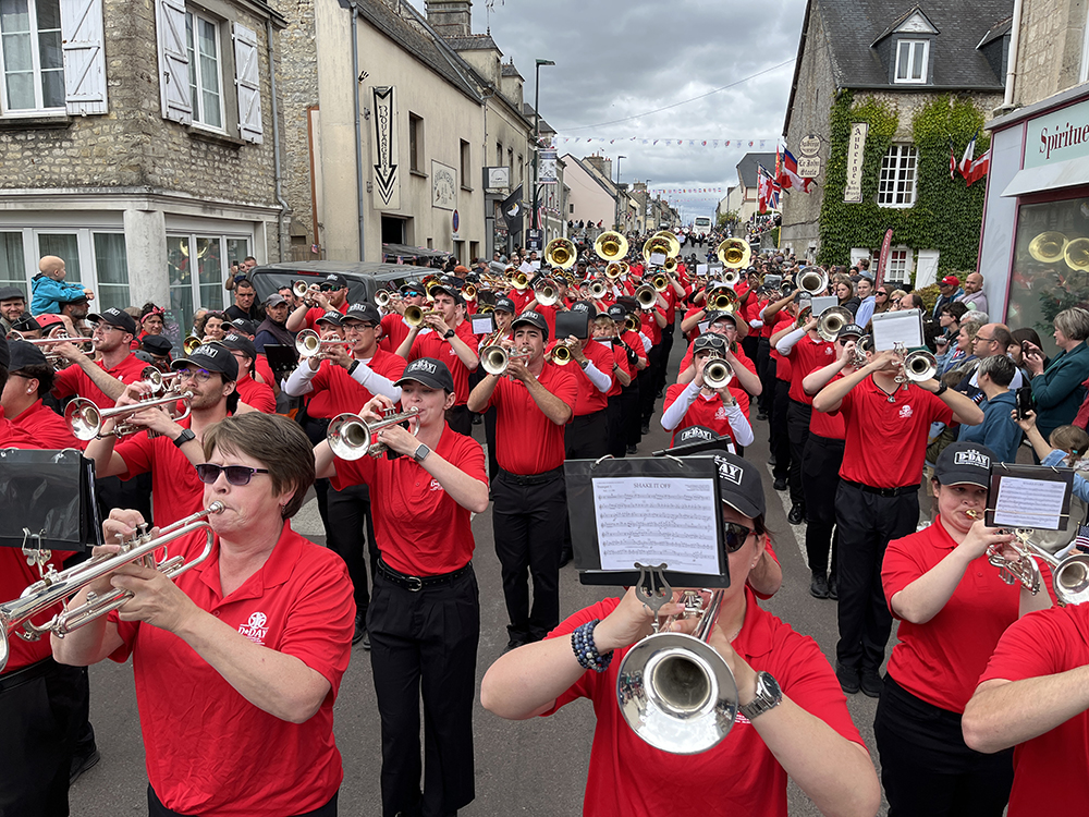 The D-Day 80th Anniversary Collegiate Mass Band, which included nine current and former members of MSU’s Famous Maroon Band, performs in the streets of Sainte-Mère-Église, the first town in France liberated by American paratroopers in 1944. 