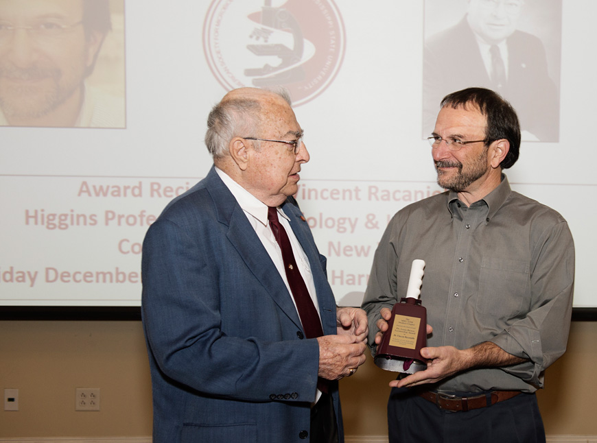 World-renowned Columbia University virologist Vincent Racaniello (r) accepts the Dr. Lewis Brown Lectureship Award given annually by MSU’s biological sciences department and American Society for Microbiology student chapter. Making the presentation was Brown himself, a research professor emeritus in the department. (Photo by Megan Bean)