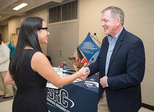 A student shakes hands with an employer representative at an MSU Career Expo