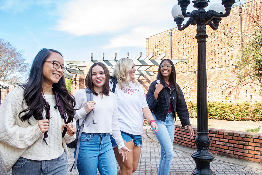 Four students walking near Chapel of Memories