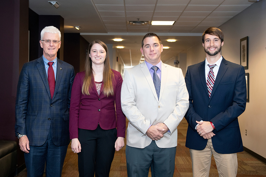 Peter Ryan (far left), associate provost for academic affairs and interim dean of Mississippi State’s Graduate School, congratulates winners of the university’s annual Three Minute Thesis competition. From left, they include Kaylee Wells of Bradenton, Florida, People’s Choice Award recipient; Michael Nattrass of Starkville, Grand Champion; and Tate Fonville of Sherwood, Arkansas, Grand Champion Runner-Up. (Photo by Beth Wynn)