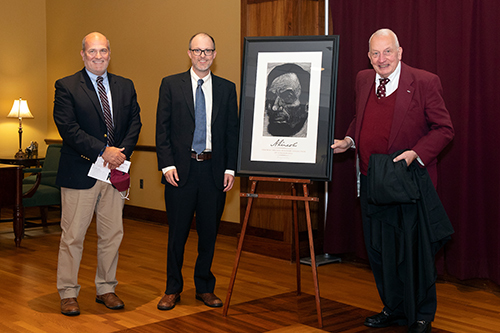 Jonathan W. White, center, receives an Abraham Lincoln print as a gift presented by MSU Interim Dean of Libraries Tommy Anderson, left, and Frank Williams, right.