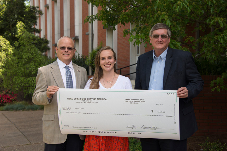 Alesa Taylor receives a check from the Weed Science Society of America and is pictured with Will Evans, head of MSU’s Department of Food Science, Nutrition and Health Promotion, and Mike Phillips, head of the Department of Plant and Soil Sciences. Taylor is working on undergraduate research under the direction of John Byrd, plant and soil sciences professor, and Sylvia Byrd, food science, nutrition and health promotion professor. (Photo submitted) 