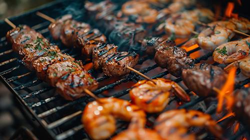 Kebabs cook on an open grill.
