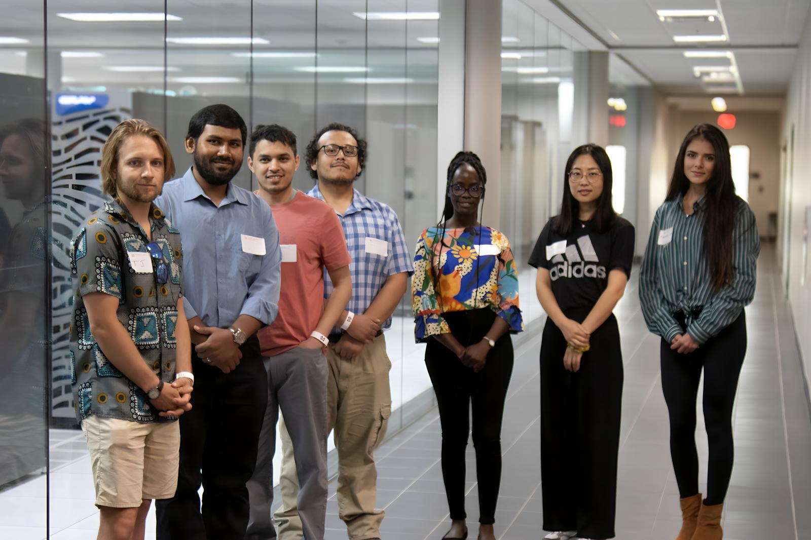 graduate students in front of glass wall
